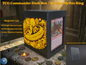 Black 3D printed TCG Commander deck box placed on a stone ritual altar background with glowing coins. The front face features a highly detailed, textured 2.5D filament painting in vibrant gold and yellow, depicting an ancient fantasy spellbook cover with an inscribed burning mythic ring. Text overlay highlights a magnetic lid and a capacity of 115 double-sleeved or 135 single-sleeved cards.