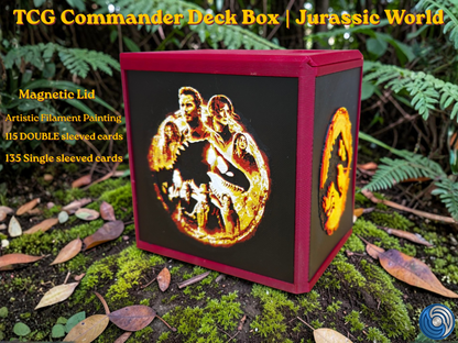 Jurassic World-themed TCG Commander deck box, UK-made 3D-printed EDH vault with HueForge artistic filament painting dinosaur design, magnetic lid, commander card display window with free premium toploader, holds 115 double-sleeved or 135 single-sleeved cards, compatible with MTG, One Piece TCG, Disney Lorcana, Flesh and Blood, Yu-Gi-Oh, Pokémon, photographed in jungle forest setting